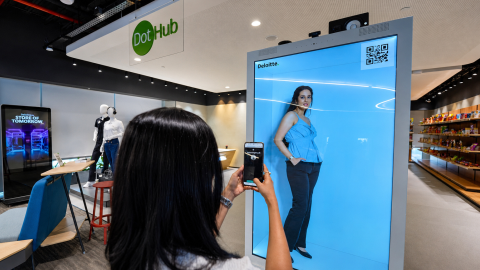 Customer using a smartphone with a smart retail avatar display inside a digital store experience.